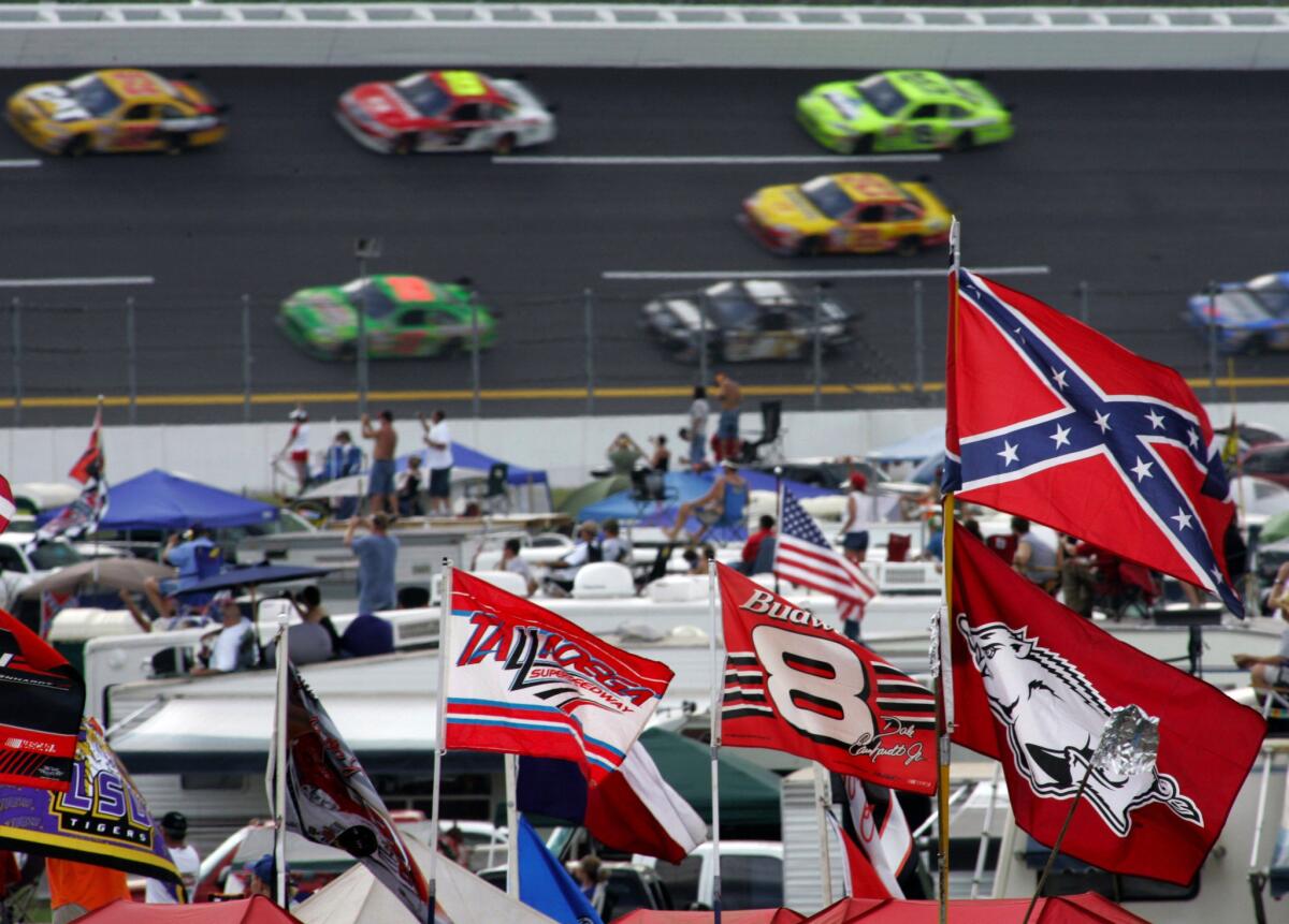 A Confederate flag flies in the infield as cars come out of a turn during a NASCAR race at Talladega Superspeedway on Oct. 7, 2007.