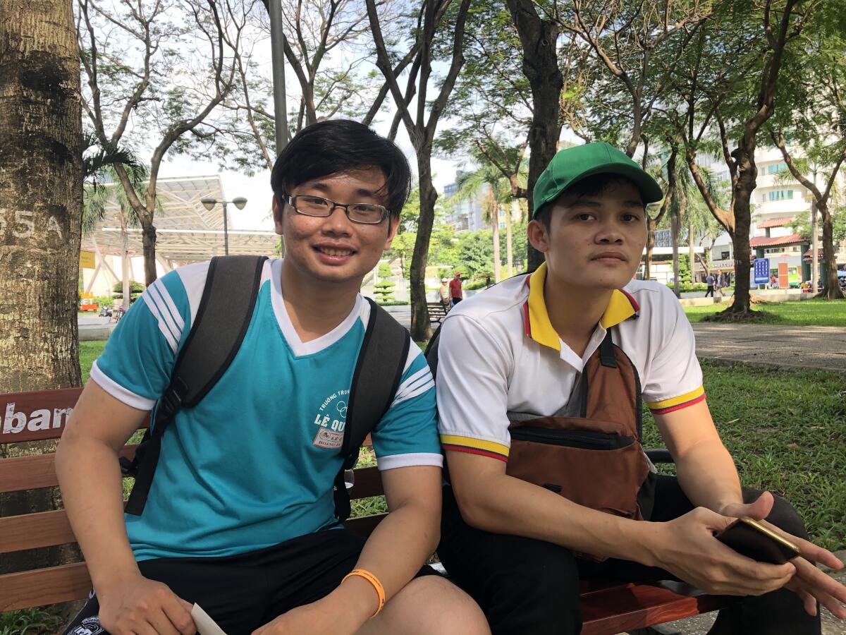 At Ho Chi Minh City's September 23 Park, Bui Hoang Duc, left, and Chanh Do Van wait to practice English with foreigners.