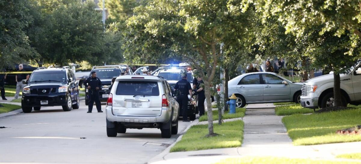 Police investigate a shooting in Katy, Texas. Officials said a woman shot her two daughters before she was killed by a police officer.