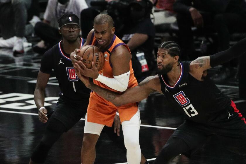 LOS ANGELES, CA - JUNE 30, 202: LA Clippers guard Paul George (13) reaches in on Phoenix Suns guard Chris Paul.