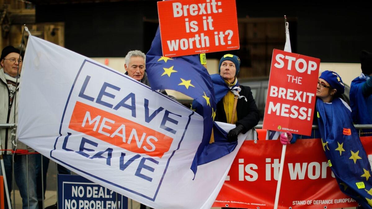 Pro- and anti-Brexit supporters hold placards and flags outside the Houses of Parliament in central London on Monday.