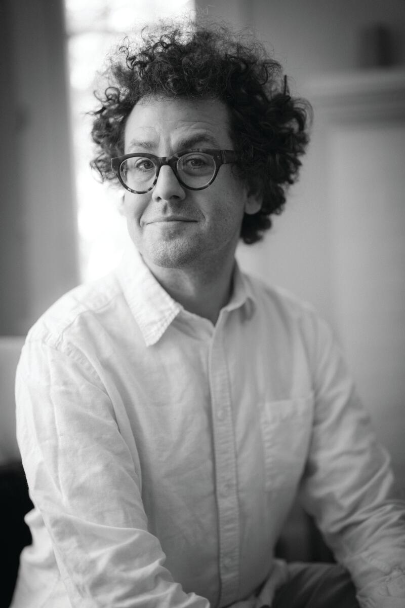 A man in glasses with bushy dark hair