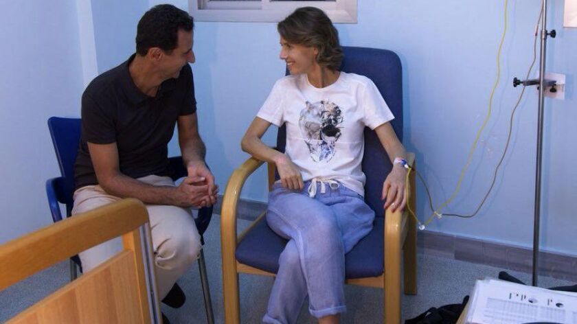 Syrian President Bashar Assad sits with his wife Asma as she begins treatment for early-stage breast cancer at a hospital in Damascus.