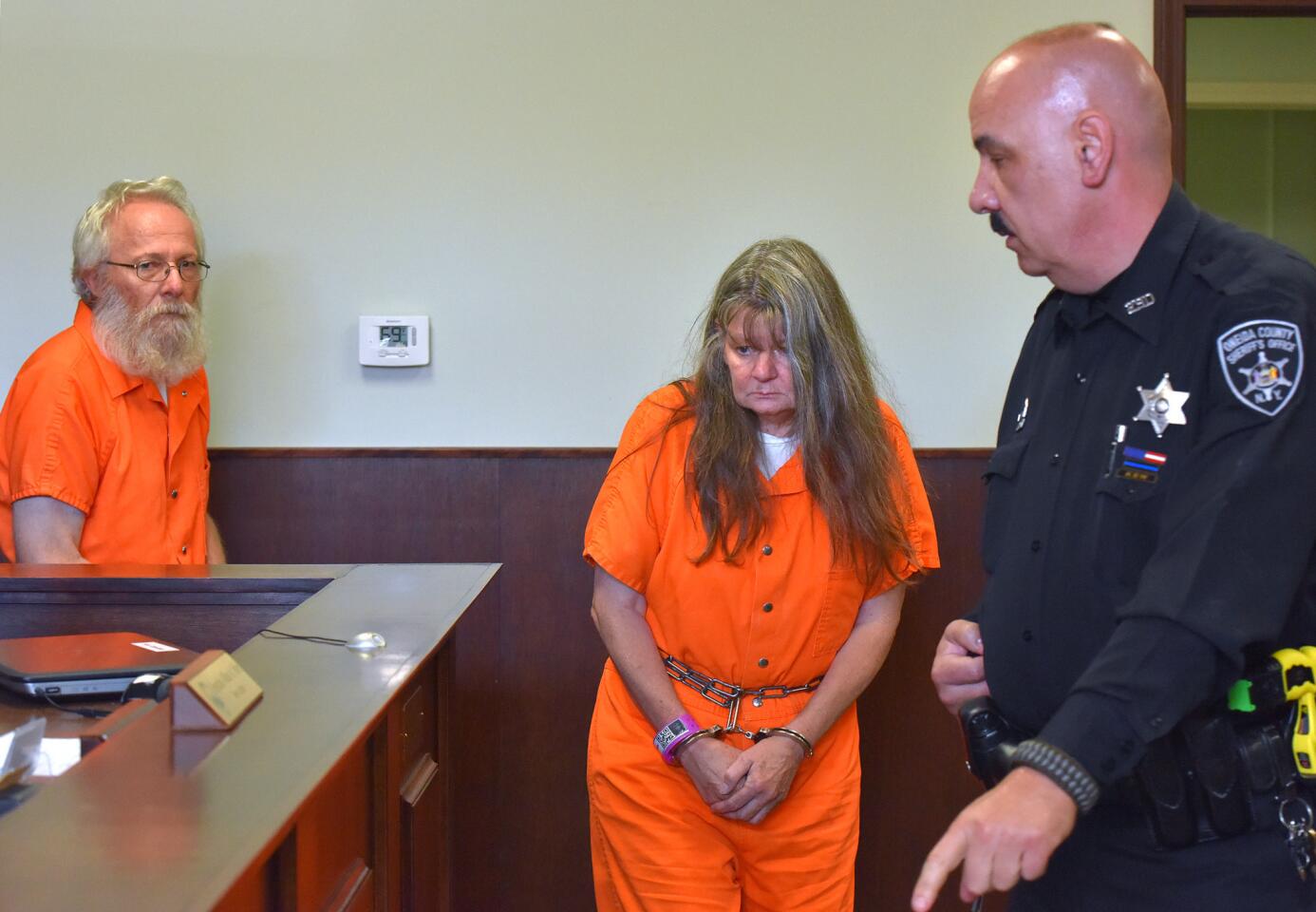 Bruce Leornard, left, and Deborah Leonard, center, enter the courtroom of before their arraignment, Tuesday, Oct. 13, 2015 in New Hartford, N.Y. The central New York couple have been charged with fatally beating their 19-year-old son inside a church, and four fellow church members have been charged with assault in an attack that also left the young man's brother severely injured, police said Tuesday.