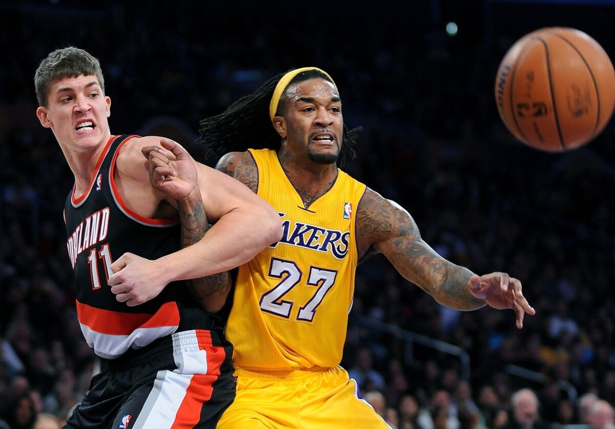 The Lakers' Jordan Hill locks up with Portland's Meyers Leonard in a game at Staples Center on Dec. 28.