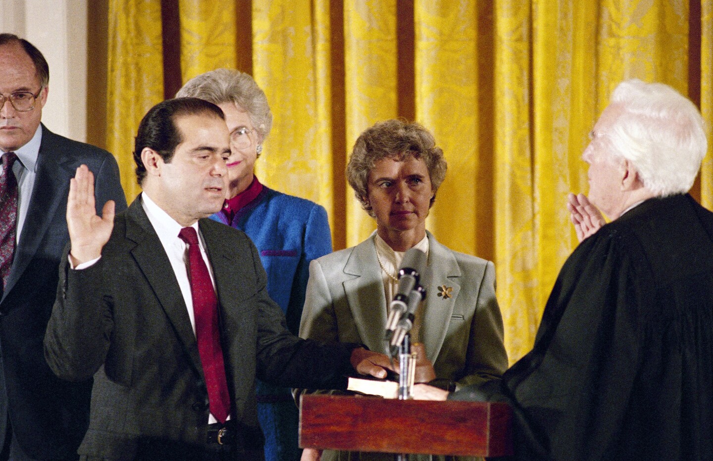 Antonin Scalia, left, with wife Maureen, takes his Supreme Court oath from retiring Chief Justice Warren E. Burger in September 1986.