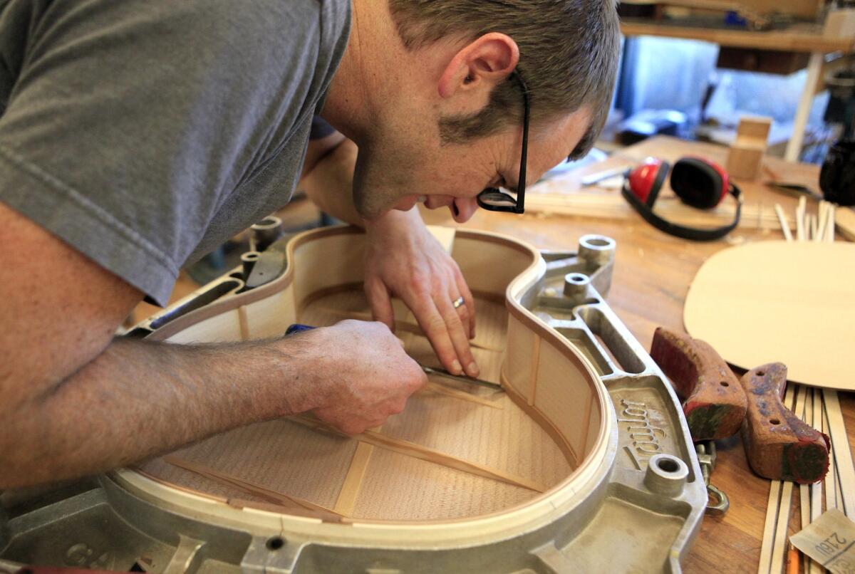Luthier Andy Powers works on the bracing of guitar top in his Taylor guitars workshop. 