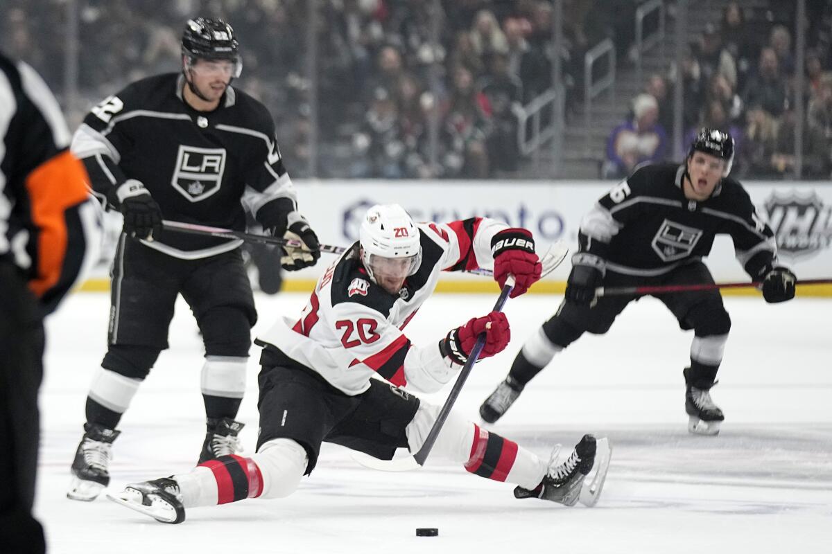 New Jersey Devils forward Michael McLeod falls while under pressure from Kings forwards Kevin Fiala Blake Lizotte.