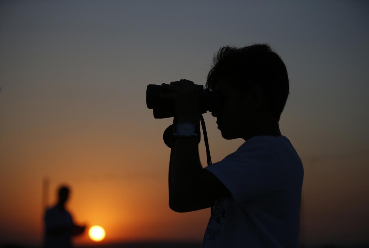 A young man looks at Turkish army tanks holding positions near the border with Syria in the outskirts of the village of Elbeyli, east of the town of Kilis, on July 23.