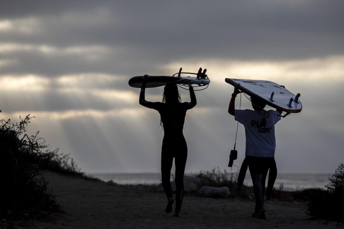 Young surfers carry their boards on their heads as they leave Rat Beach in Palos Verdes Estates earlier this week.