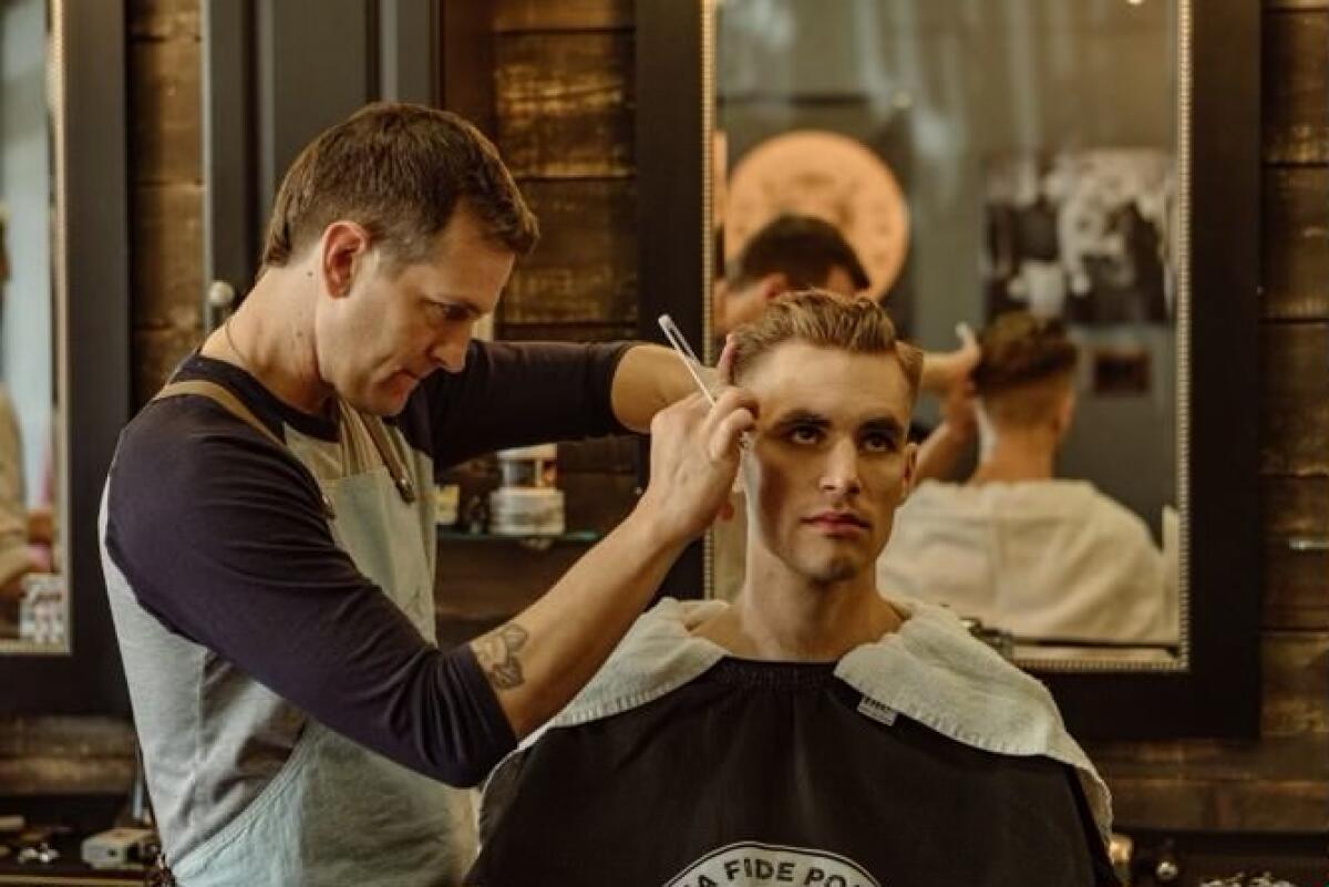 Jake Bushnell, left, cuts hair at American Vintage Barber Shop in Long Beach.