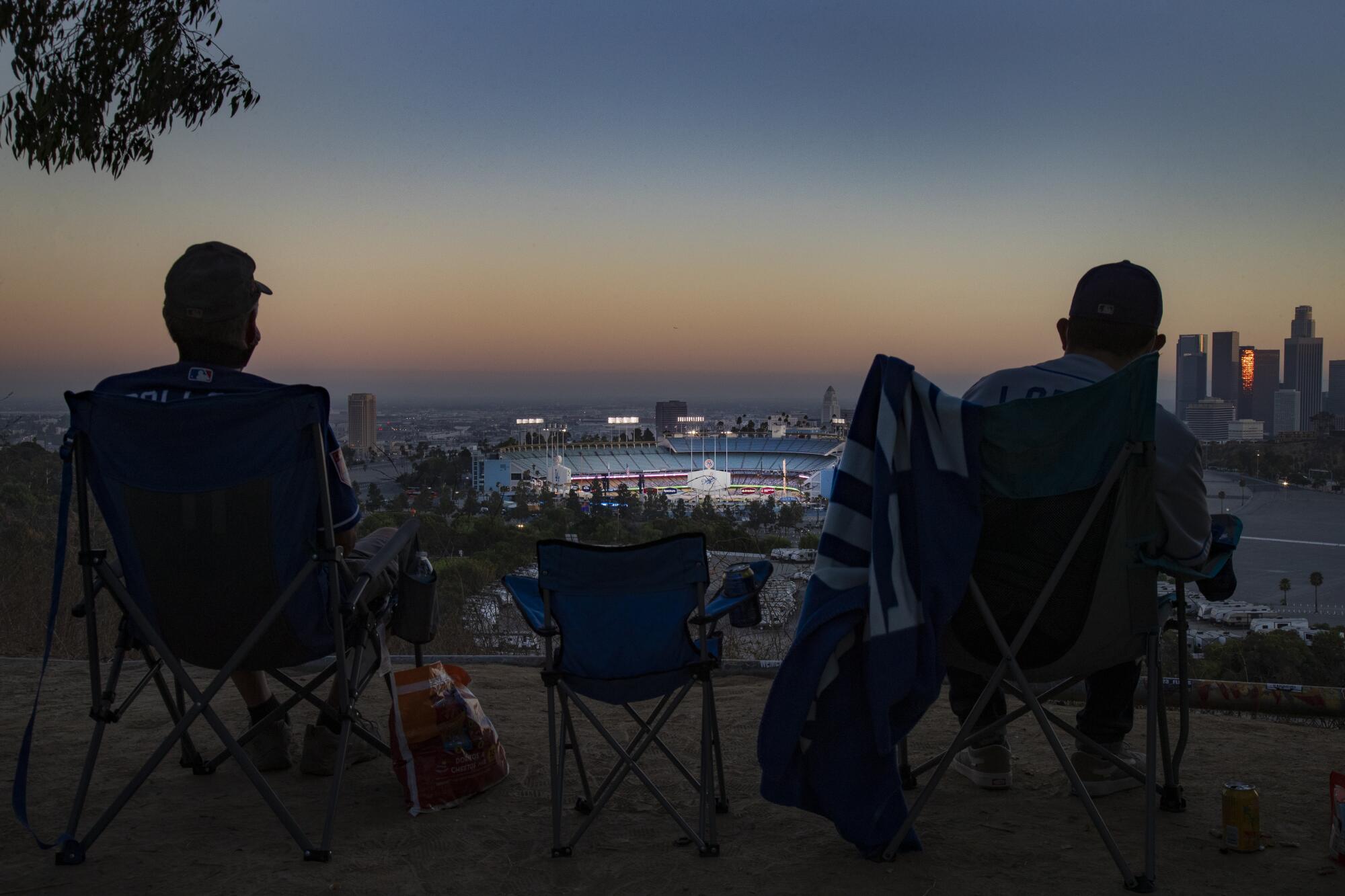 Season ticket holder Keith Hupp, left, and David Lopez, right, watch the Dodgers play 