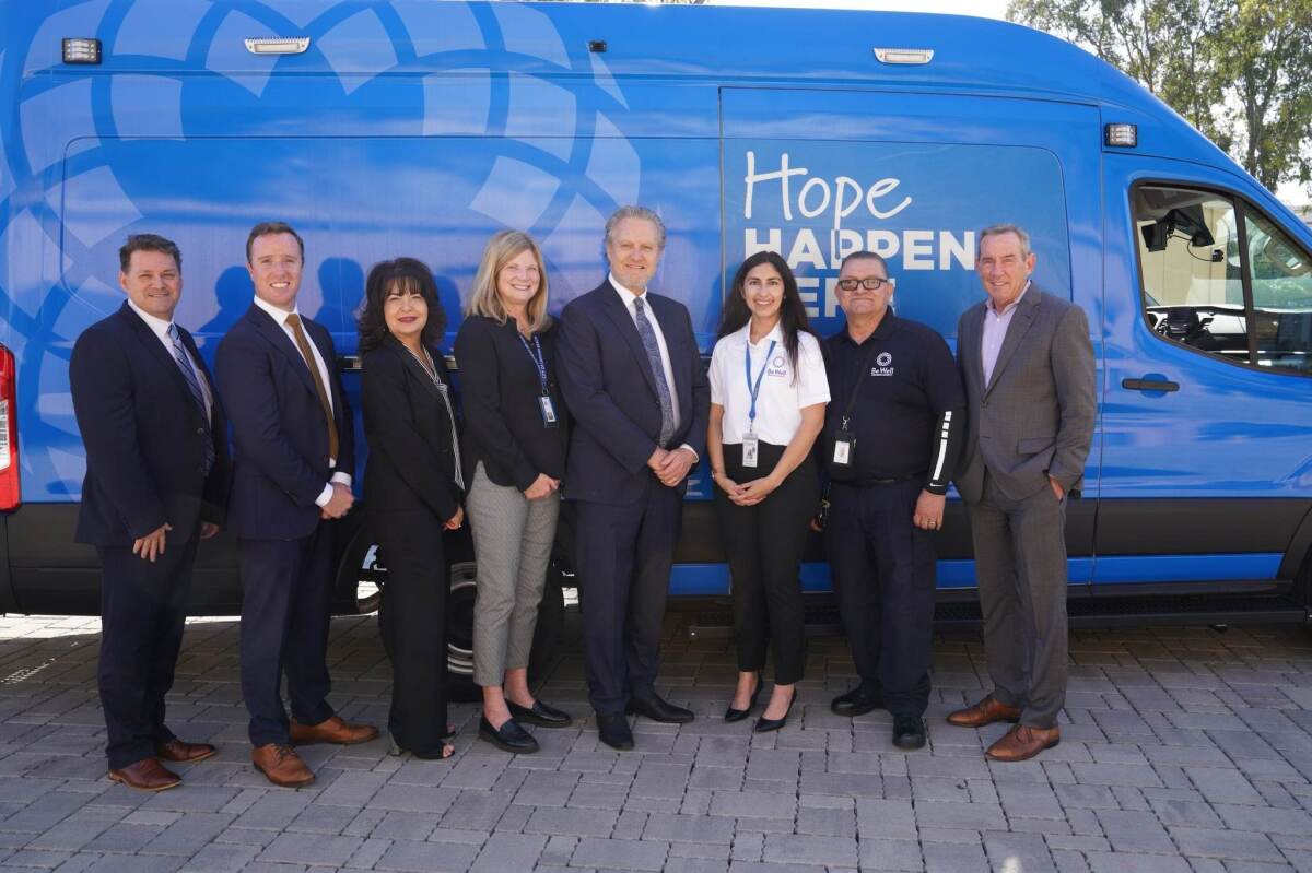 Laguna Beach city officials and Be Well OC team members pose in front of a Be Well OC mobile response team van.