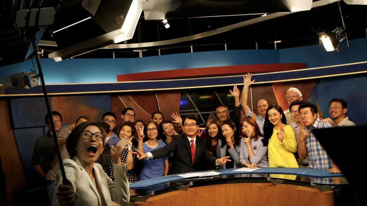 Pheel Wang, a reporter-anchor at KSCI Channel 18, takes a selfie with crew members Friday after their final Mandarin newscast.