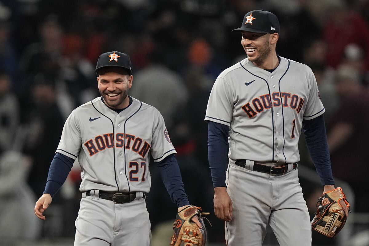 Houston Astros second baseman Jose Altuve and shortstop Carlos Correa email after their win in Game 5 of baseball's World Series between the Houston Astros and the Atlanta Braves Monday, Nov. 1, 2021, in Atlanta. The Astros won 9-5. The Braves lead the series 3-2 games. (AP Photo/Brynn Anderson)