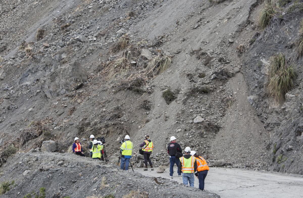 Caltrans officials and media members gather on Highway 1 where a massive landslide cut off the road north of Ragged Point.