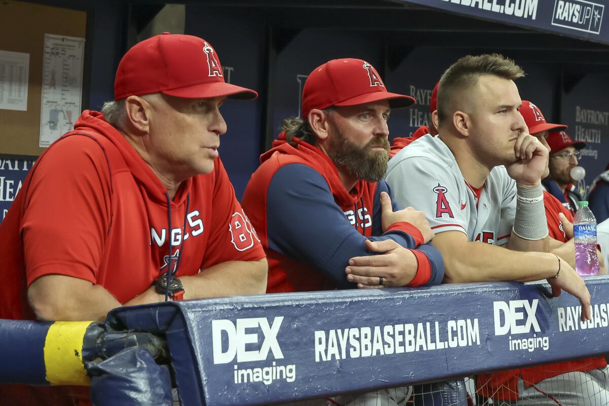 Angels manager Phil Nevin, hitting coach Jeremy Reed and Mike Trout look on.