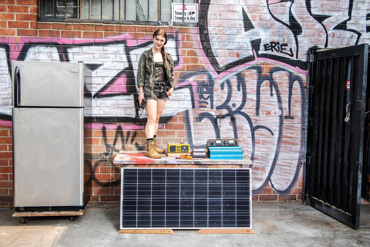 Bee Burlingame poses outside her workspace with the materials she will use to create L.A.'s first solar community fridge.