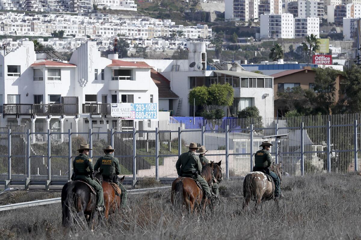 Botder Patrol officers on horseback patrol near the border wall in Imperial Beach on Thursday, Nov. 15, 2018.