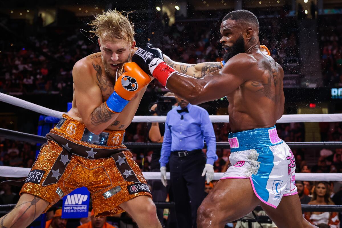 Tyron Woodley, right, punches Jake Paul during their boxing match on Sunday.