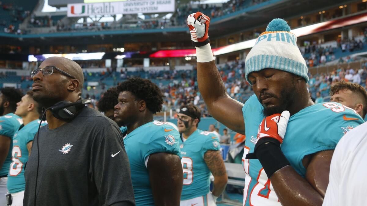 Miami Dolphins defensive end Robert Quinn raises his right fist during the singing of the national anthem before the team's NFL preseason football game against the Tampa Bay Buccaneers on Aug. 9.