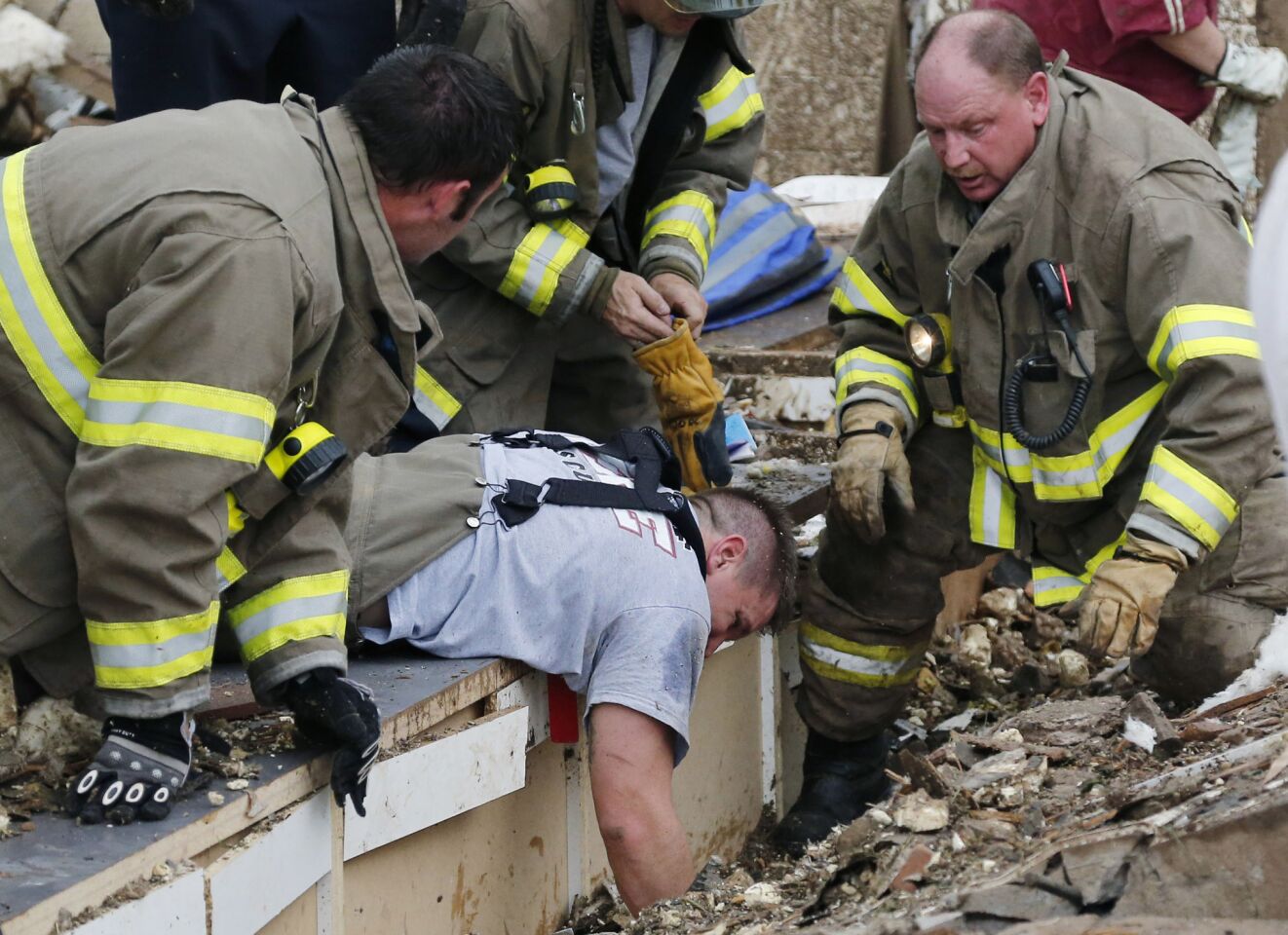 Rescue workers dig through the rubble of a collapsed wall at the Plaza Tower Elementary School to free trapped students in Moore, Okla.