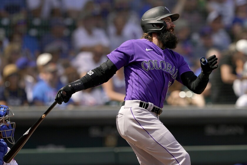 Colorado Rockies' Charlie Blackmon follows through on a base hit against the Chicago Cubs during the first inning of a spring training baseball game, Friday, March 25, 2022, in Mesa, Ariz. (AP Photo/Matt York)