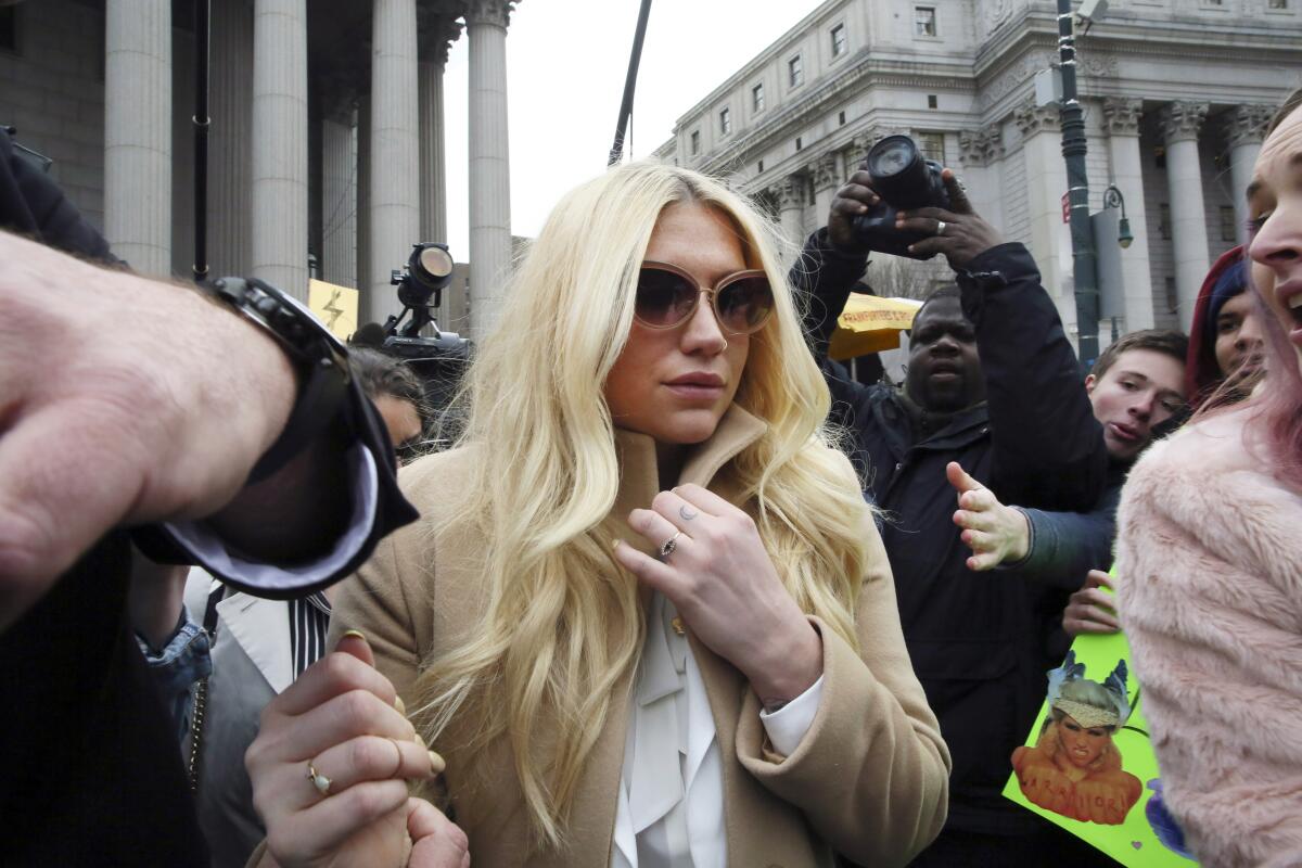 Kesha leaves a courthouse surrounded by a crush of people and cameras