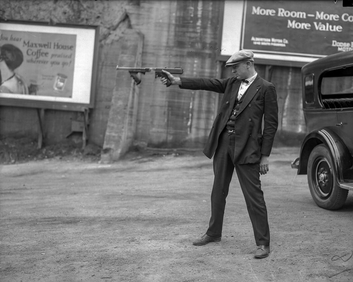 LAPD Det. Lt. Oscar Bayer, the hero of a 1925 shootout, poses in a circa 1927 photo aiming a Thompson submachine gun -- without a magazine.
