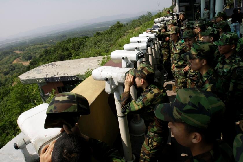 FILE - South Korean soldiers look at the North Korean side through binoculars at Dora Observation Post in the demilitarized zone, DMZ, near the border village of Panmunjom that separates the two Koreas since the Korean War, in Paju, north of Seoul, South Korea, Wednesday, May 27, 2009. A series of low-slung buildings and somber soldiers dot the landscape of the DMZ, the swath of land between North and South Korea where a soldier on a tour crossed into North Korea on Tuesday, July 18, 2023, under circumstances that remain unclear. (AP Photo/Lee Jin-man, File)