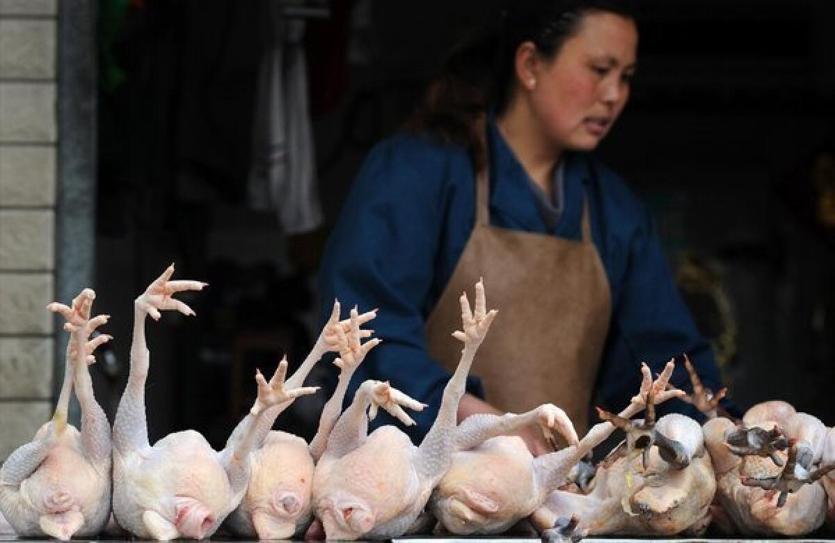 A Chinese vendor washes a chicken stall in a poultry market that was set to be closed because of the influence of bird flu in Hefei, China.