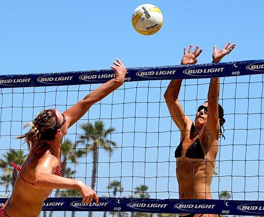 Angie Akers, right, goes up to try to block Ashley Ivy in a second-round match Friday at the AVP Crocs Tour tournament at Huntington Beach.