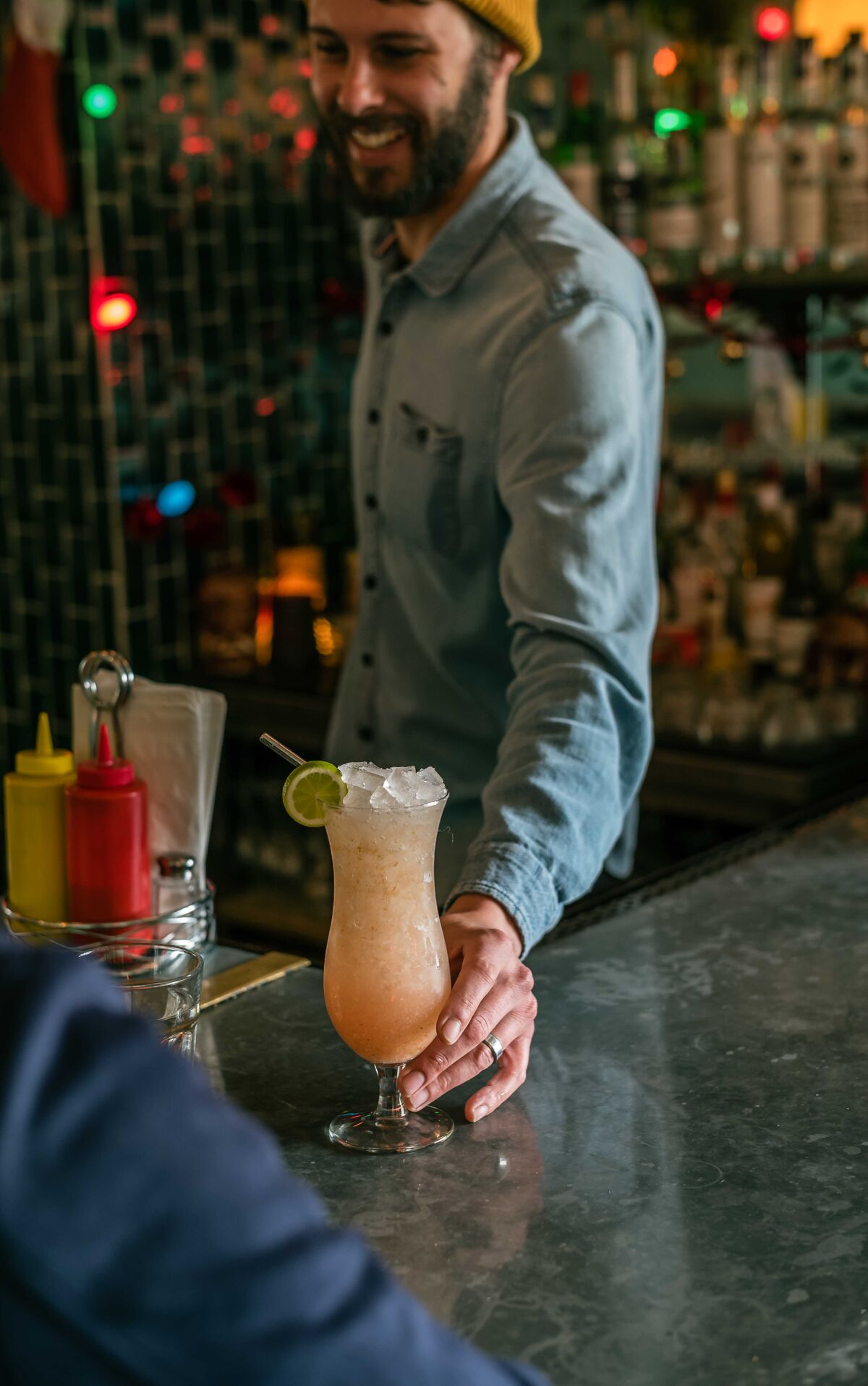 Co-owner Jordan Brownwood serves a cocktail made with fresh guava from the family’s Nopalito Farm in Valley Center.