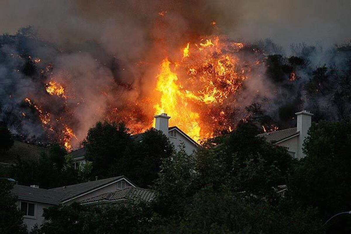 A back fire burns along a ridge above homes on Sky Ridge Drive in La Crescenta.