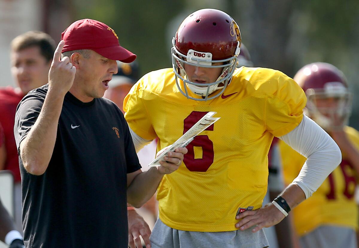 USC offensive coordinator Clay Helton works with quarterback Cody Kessler during a practice at USC. The two are hoping to cut down penalties in the game against Utah on Saturday.