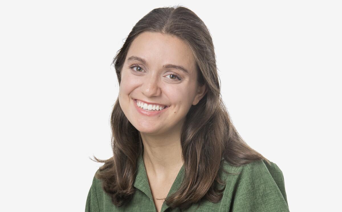 Christi Carras smiles in a green blouse.
