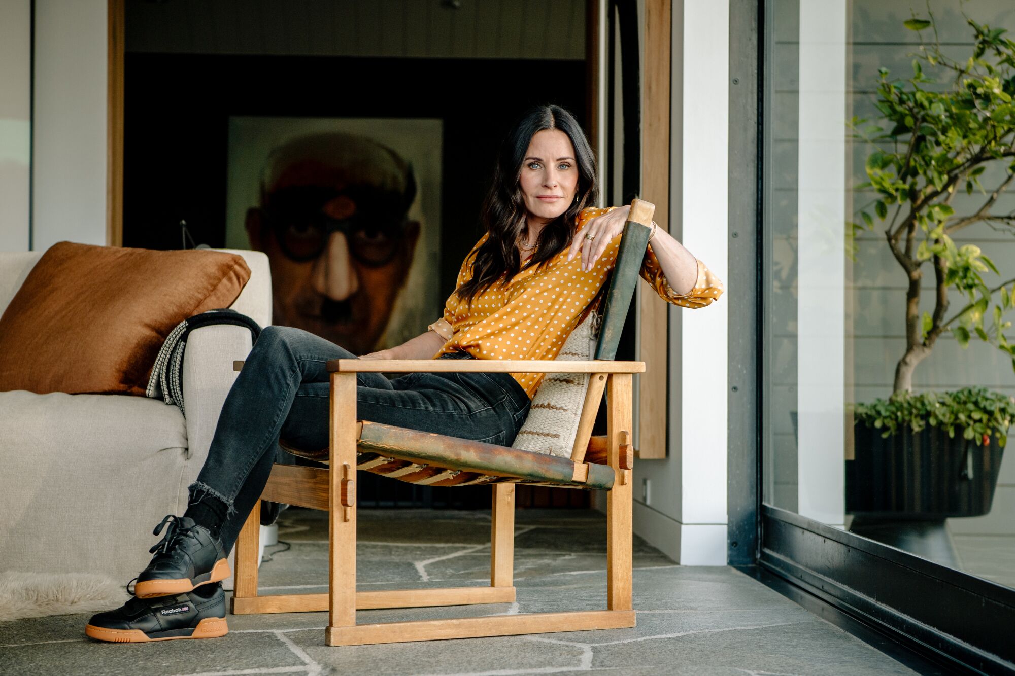 Cox poses in a chair inside her home.
