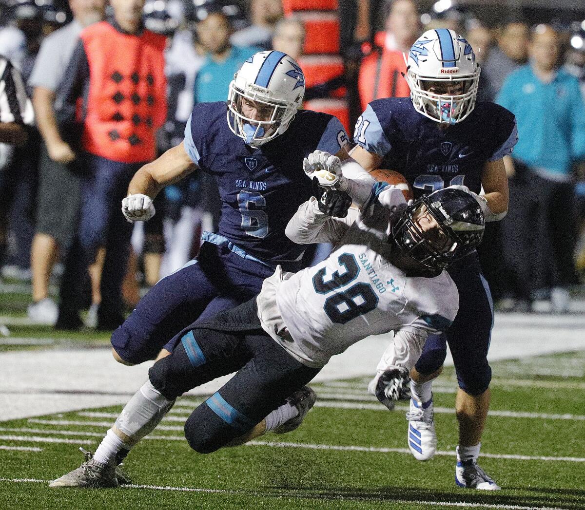 Corona del Mar's John Humphreys, left, puts a block on Santiago's Aiden Boon to free running back Riley Binnquist for a touchdown in the first round of the CIF Southern Section Division 3 playoffs on Friday at Newport Harbor High.