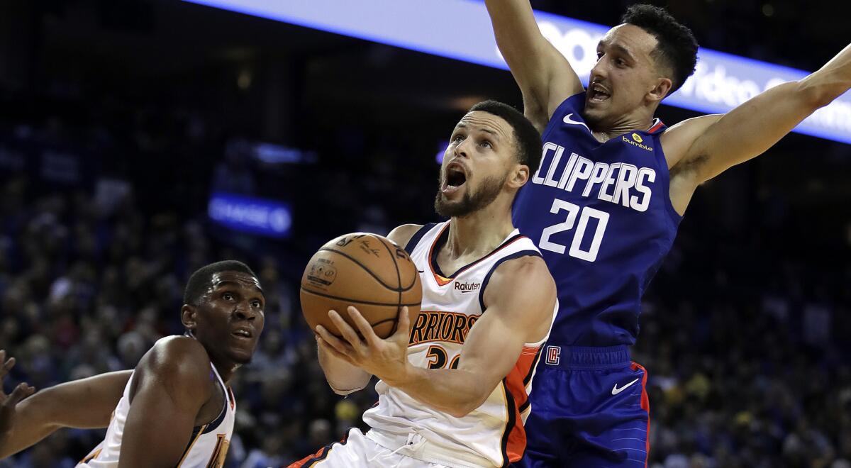 Warriors guard Stephen Curry tries to score against the defense of Clippers guard Landry Shamet during a game Sunday in Oakland.