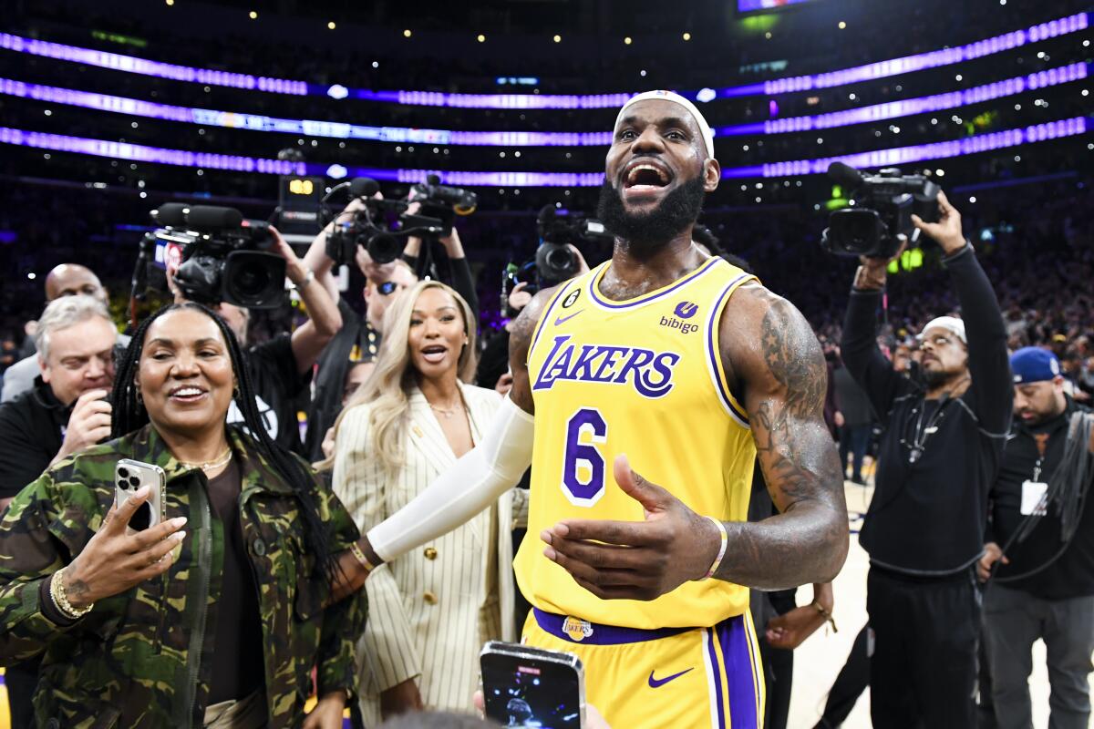 LeBron James stands with his mother Gloria and wife Savannah after passing Kareem Abdul-Jabbar as the NBA's scoring leader.