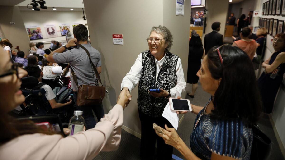 Jackie Goldber greets people before the Los Angeles school board meeting.
