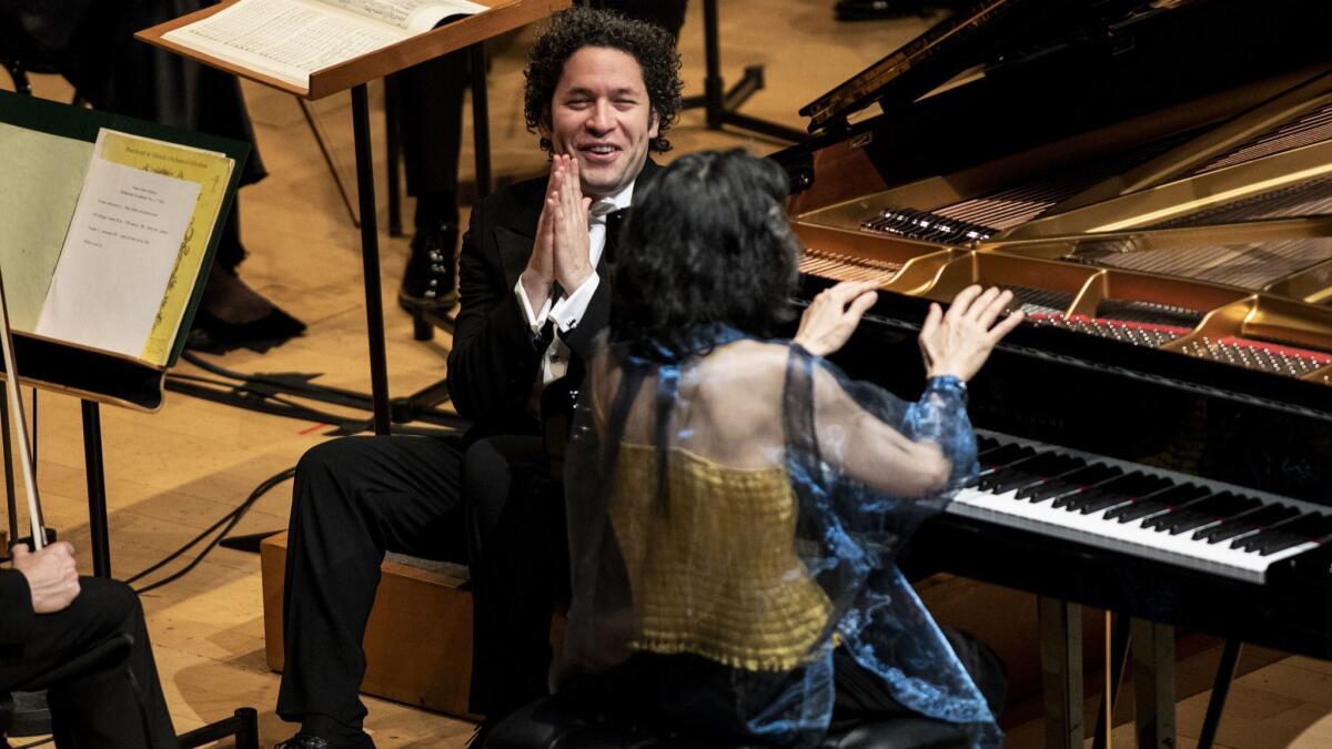 Gustavo Dudamel listens to Mitsuko Uchida's encore after their performance of Schumann's Piano Concerto at Walt Disney Concert Hall Thursday night
