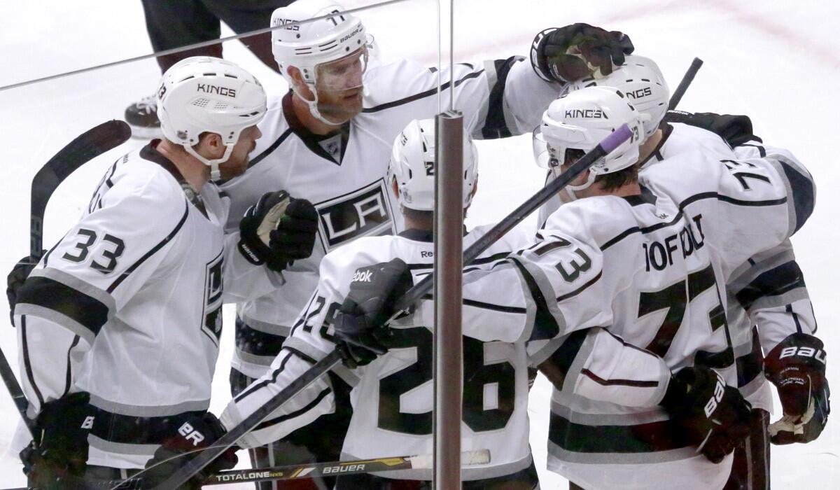 Kings center Jeff Carter congratulates rookie forwards Tanner Pearson, who assisted on a goal, and Tyler Toffoli (73), who scored, during their 6-2 win over the Blackhawks on Wednesday. Joining the celebration are defensemen Willie Mitchell (33) and Slava Voynov (26).
