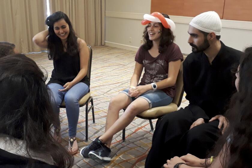 Daniel Halabi, 22, right, a sheikh, or religious leader in the Druze faith, leads a discussion with Carmen Masri, 22, left, and Luna Masri, 15, during a youth group meeting at the American Druze Society conference in Irvine, in July.