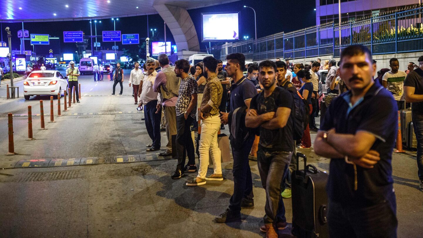 Passengers wait outside Ataturk Airport in Istanbul after Tuesday's attack.