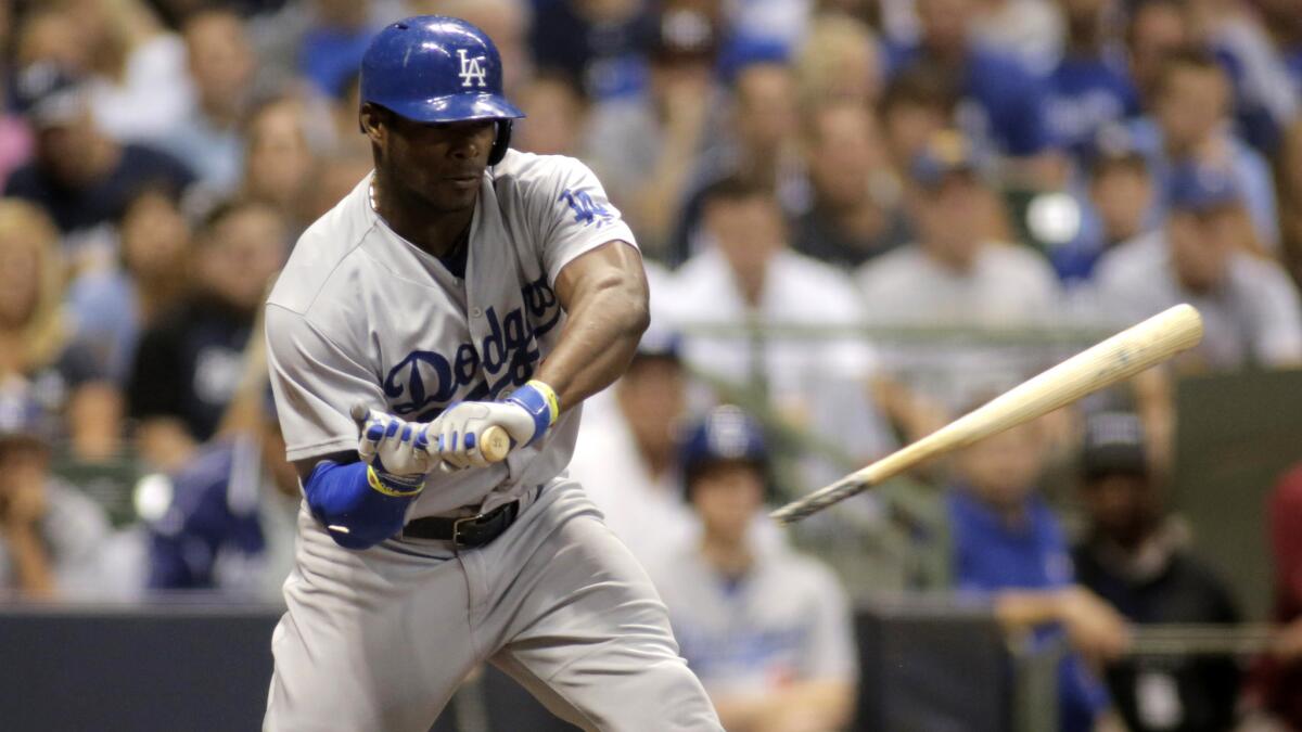 Dodgers center fielder Yasiel Puig breaks his bat on a check-swing during a loss to the Milwaukee Brewers on Friday.