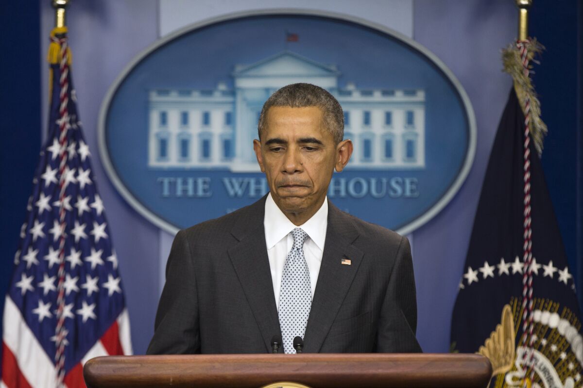 President Obama pauses as he speaks about the attacks in Paris during a White House news conference on Friday.