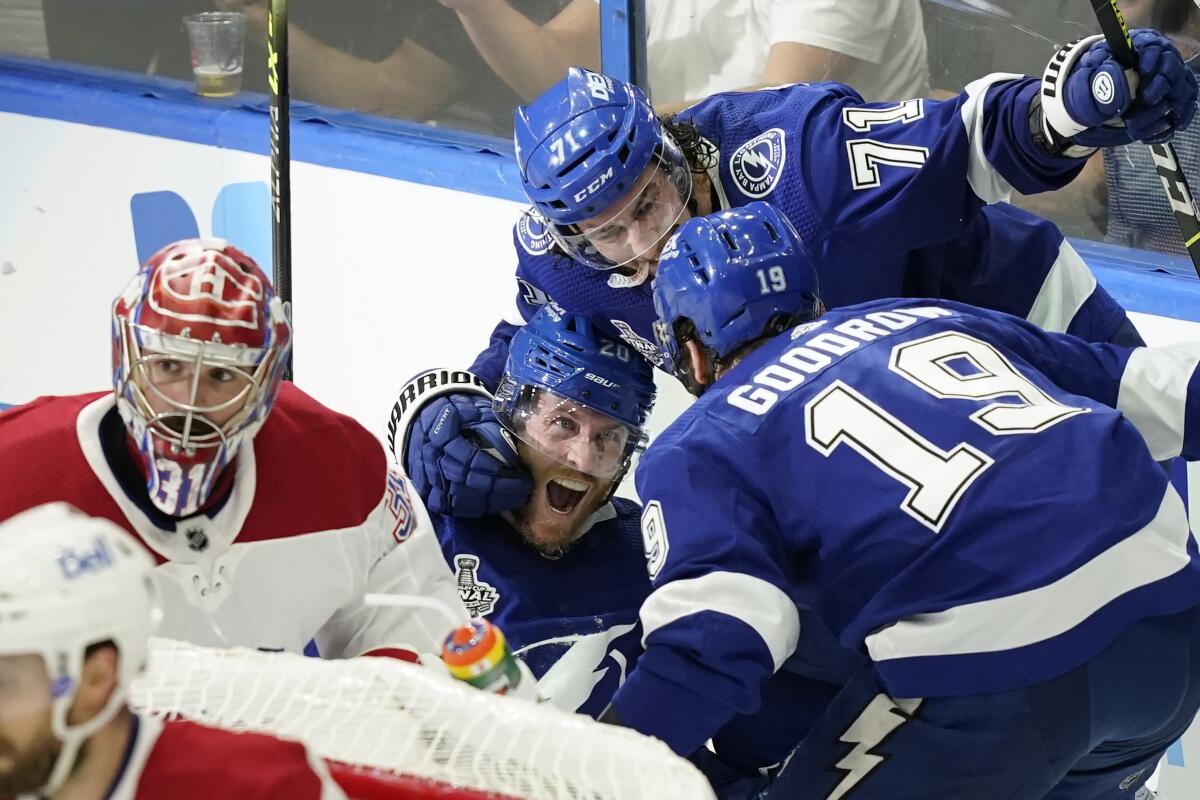 Tampa Bay's Blake Coleman celebrates with Anthony Cirelli and Barclay Goodrow behind Montreal goaltender Carey Price.