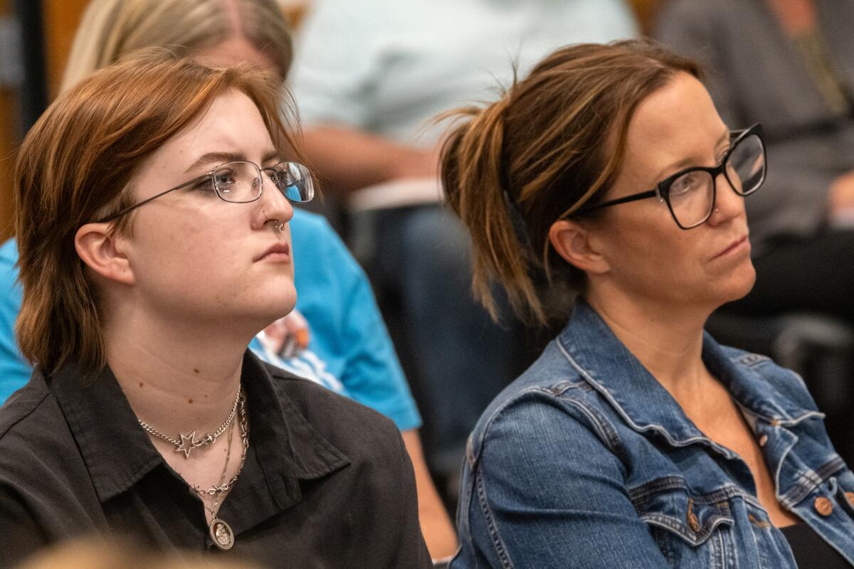 Avery Poznanski and Poznanski's mother, Karen, sit together at a Murrieta Valley Unified school board meeting. 