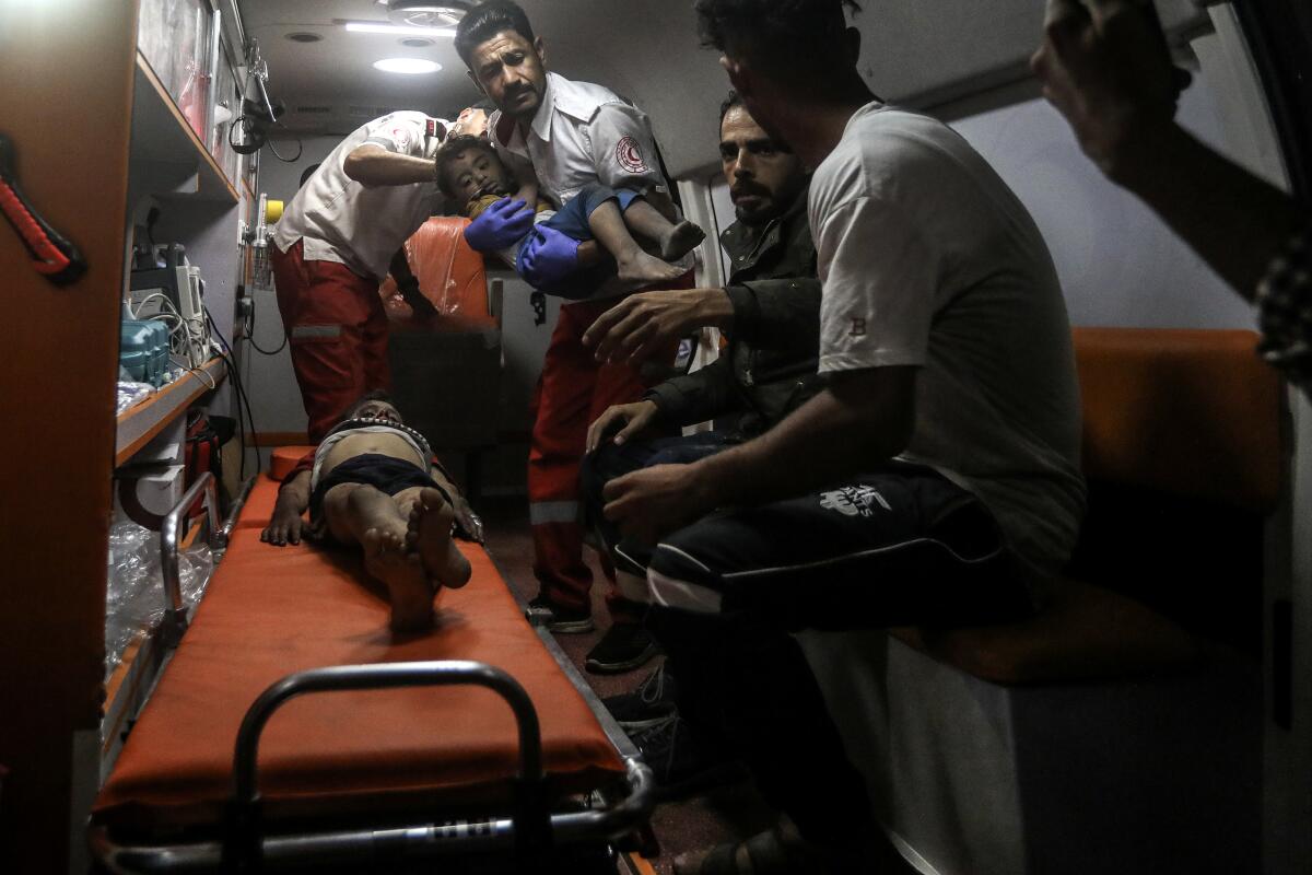 Palestinian medics in an ambulance care for wounded children.